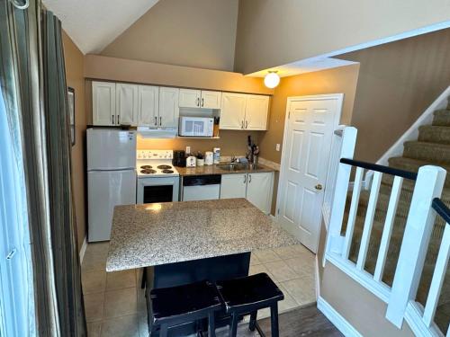 a kitchen with white cabinets and a counter top at Mountain Loft Suite with Pool and Hot Tub in Blue Mountains
