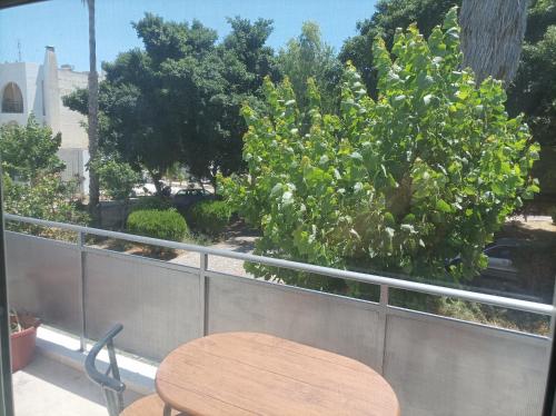 a table and chair on a balcony with a tree at Euphemia's Apartment in Ampavris