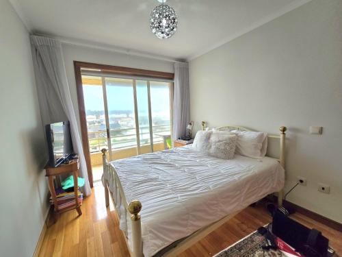 Un dormitorio con una cama y una ventana grande en Holidays appartment, en Furadouro
