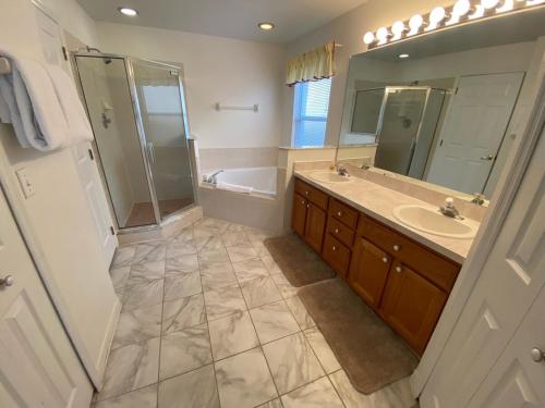 a bathroom with a tub and a sink and a shower at Dunes Hideaway Pool Home Southern Dunes in Haines City