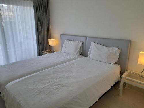 a bedroom with a large bed with white sheets and pillows at Victory Village 3A in Quinta do Lago