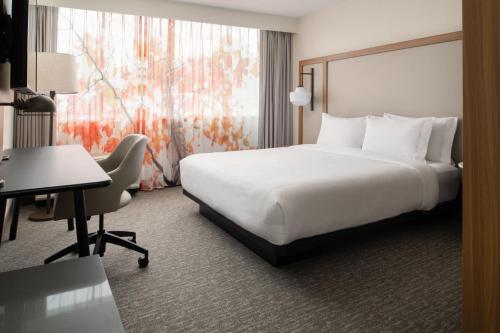 a hotel room with a large white bed and a desk at Fairfield by Marriott Issaquah in Issaquah