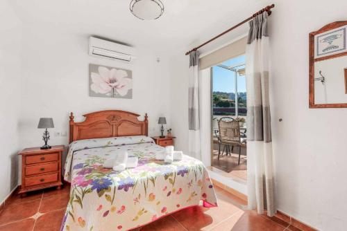 een slaapkamer met een bed en een balkon bij Villa Cecilia Sol in Torrox