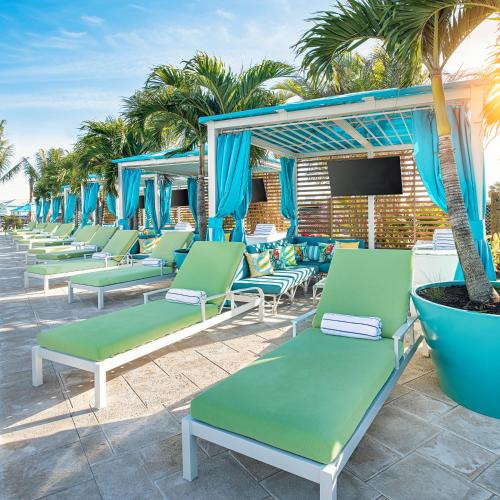 a row of chaise lounges on a beach at Margaritaville Beach Resort Ft Myers Beach in Fort Myers Beach