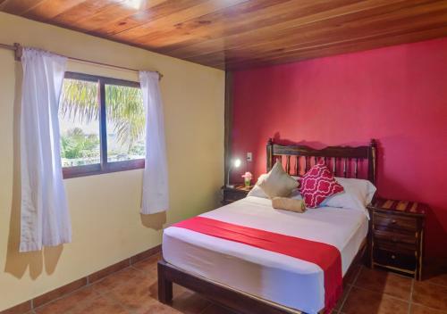 a bedroom with a bed with a red wall at Cabañas Linda Vista in Chimo