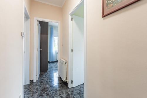 a hallway with white walls and a hallway with a radiator at Casa de vacances Mary in Santa Eulalia de Ronsaná