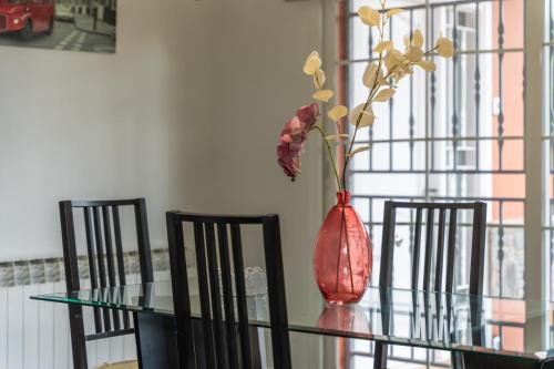 a vase sitting on a glass table with three chairs at Casa de vacances Mary in Santa Eulalia de Ronsaná