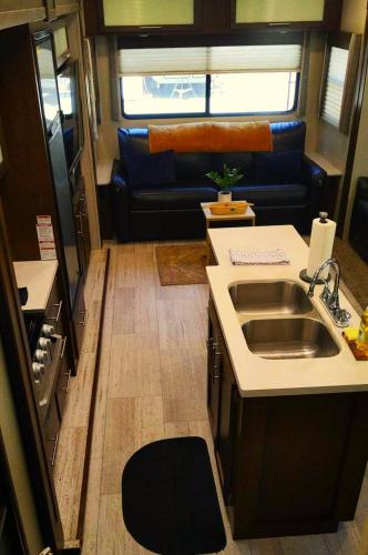an rv kitchen with a sink and a couch at RV42 with Large Deck on a Creek in O'Brien