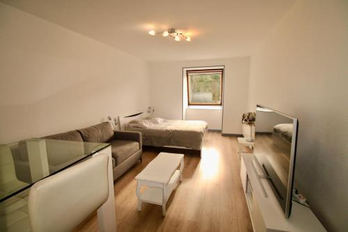 un salon avec un canapé et un lit dans l'établissement Residence les Flots Bleu Trouville-sur-Mers, à Trouville-sur-Mer