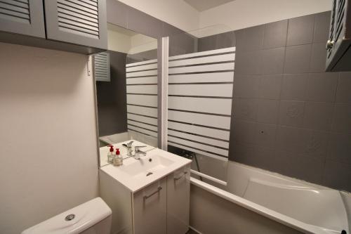 une salle de bain avec un lavabo, des toilettes et un miroir dans l'établissement Residence les Flots Bleu Trouville-sur-Mers, à Trouville-sur-Mer