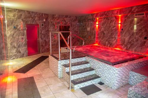 a bathroom with a tub with red lighting and stairs at Broad Larch Lodge in Bowness-on-Windermere