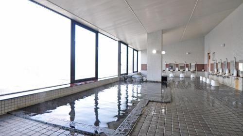a pool of water in a large room with windows at Rikuchu Kaigan Grand Hotel - Vacation STAY 88515v in Kamaishi