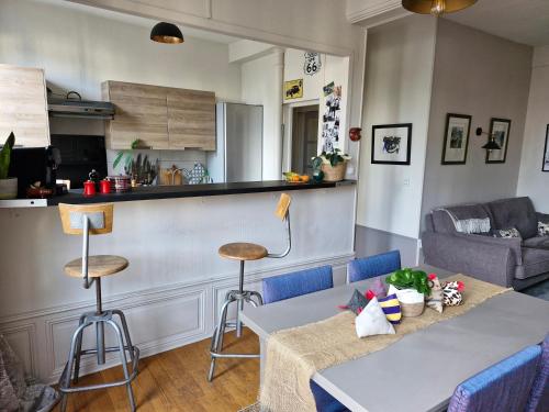 un salon avec deux tables et une cuisine dans l'établissement Le Monde d'Alex, à Troyes