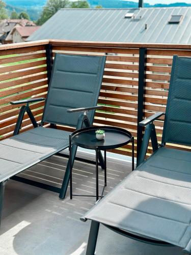 two blue chairs and a table on a balcony at Apartmán Bezinka in Lipno nad Vltavou