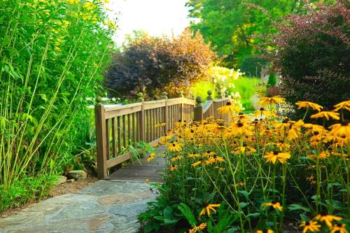 a garden with a wooden fence and yellow flowers at Azalea Garden Inn in Blowing Rock
