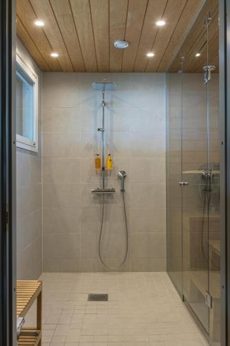 a bathroom with a shower with a glass door at Villa Bläk in Alavus