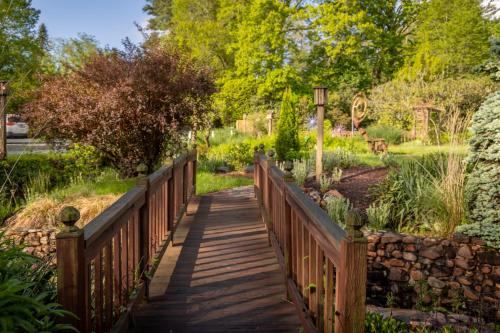 a wooden bridge over a garden in a park at Azalea Garden Inn in Blowing Rock