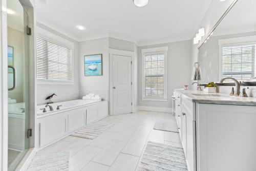 a white bathroom with a tub and a sink at Uncloudy Day - 1216 Demere Road in Mallory Park