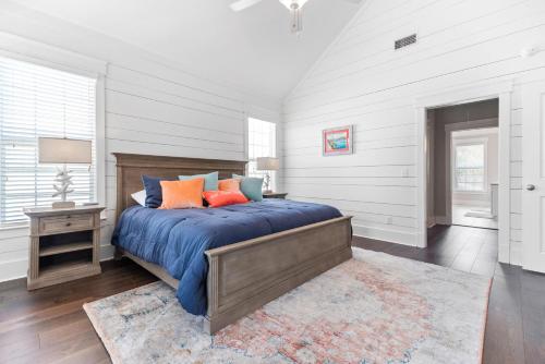 a bedroom with a bed with blue sheets and orange pillows at Uncloudy Day - 1216 Demere Road in Mallory Park