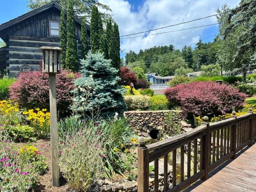 a garden with flowers and a wooden fence at Azalea Garden Inn in Blowing Rock