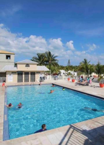a swimming pool with people in the water at Key Largo Paradise in Key Largo
