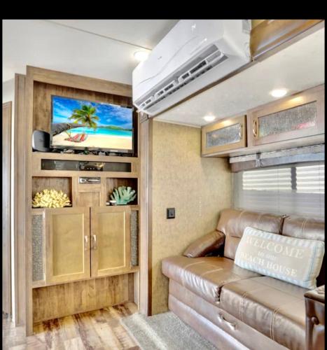 a living room with a couch and a tv in a rv at Key Largo Paradise in Key Largo