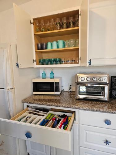 a kitchen with white cabinets with an organized drawer at Key Largo Paradise in Key Largo