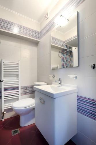 a white bathroom with a toilet and a sink at dreamOn in Lefkada