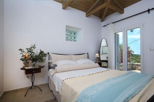 a white bedroom with a bed and a mirror at dreamOn in Lefkada