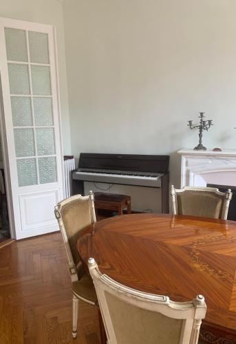une salle à manger avec une table et un piano dans l'établissement Appart stylé ancienne centre ville - 7 min plage, à Beaulieu-sur-Mer