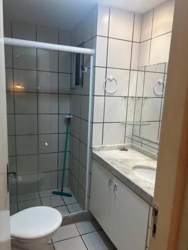 a bathroom with a toilet and a sink and a mirror at Apartamento no Icaraí in Caucaia