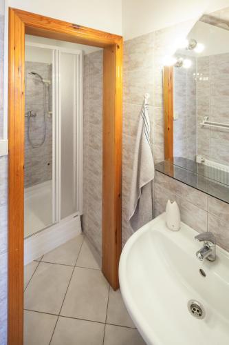 a bathroom with a white sink and a shower at Pension Fontána Svitavy in Svitavy