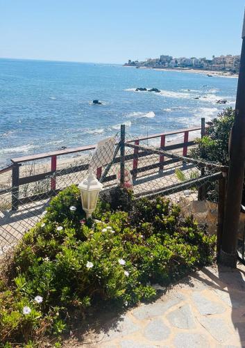 a street light next to a fence and the ocean at Tranquil Oceanfront Escape, One-Bedroom Haven in Mijas