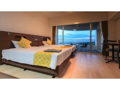 a bedroom with two beds with a view of the ocean at Hotel Sunset Hill - Vacation STAY 94794v in Nakadomari