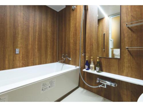 a bathroom with a bath tub and a mirror at Hotel Sunset Hill - Vacation STAY 94794v in Nakadomari