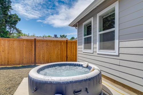 a hot tub on a patio next to a house at Charming Westport Abode with Hot Tub, Deck and Yard! in Westport