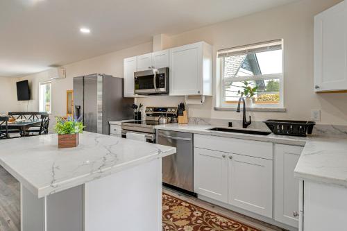 a kitchen with white cabinets and a counter top at Charming Westport Abode with Hot Tub, Deck and Yard! in Westport