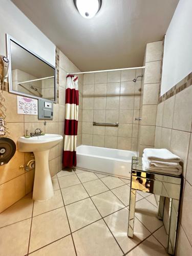 a bathroom with a tub and a sink and a toilet at Hotel Dial in Guadalupe Victoria