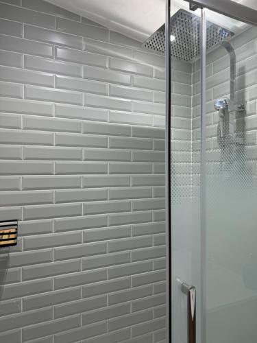 une douche avec une porte vitrée dans une salle de bain dans l'établissement Charmant studio lumineux à Chaville, à Chaville