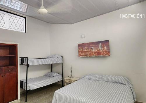 a bedroom with two beds and a shelf and a painting at Casa villa con Jacuzzi, tobogán y BBQ in Carmen de Apicalá