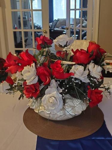 a vase of red and white flowers on a table at Blue Ocean Family vacation Luxury Suite in Halifax