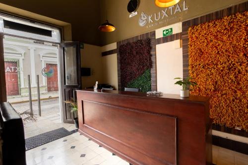 a front desk of a restaurant with a sign on the wall at Kuxtal Hotel Boutique in Mérida