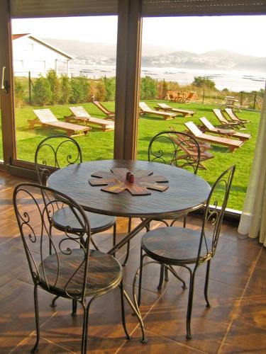 a table and chairs in a room with a large window at A Maquia in Poio