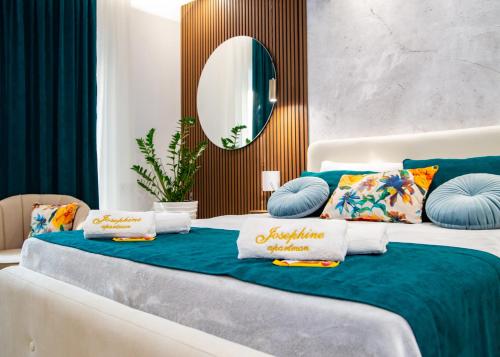 a bed with blue and white pillows on it at Josephine Apartment in Subotica
