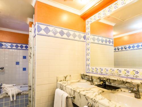 a bathroom with two sinks and a mirror at Apartamentos BlueBay Beach Club in San Agustin