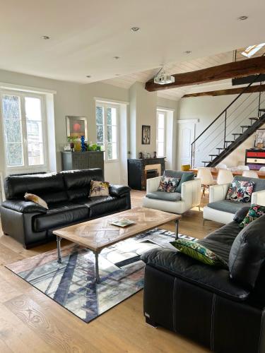 - un salon doté d'un mobilier en cuir noir et d'une table basse dans l'établissement Bureau51– Centre Historique AUCH, à Auch