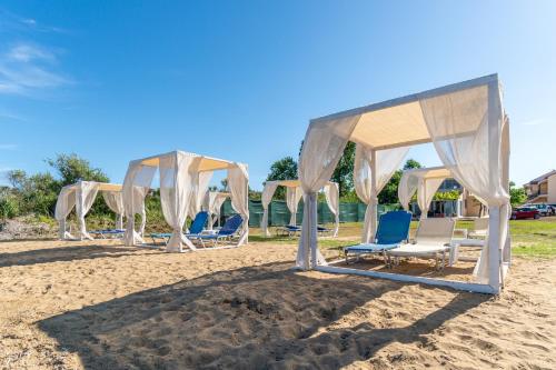 a group of chairs and a canopy on the beach at Sandy Beach Complex - Annexe Building in Kavos