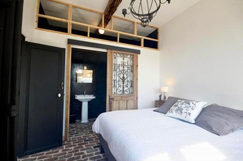 a bedroom with a bed and a sink and a window at Orangerie du chateau in Hugleville-en-Caux