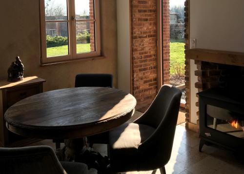 a dining room with a table and chairs and a fireplace at Orangerie du chateau in Hugleville-en-Caux