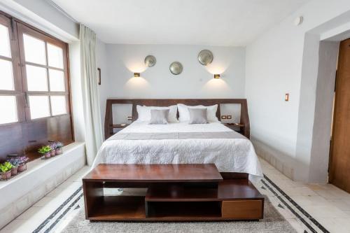 a bedroom with a bed and a wooden table at Kuxtal Hotel Boutique in Mérida